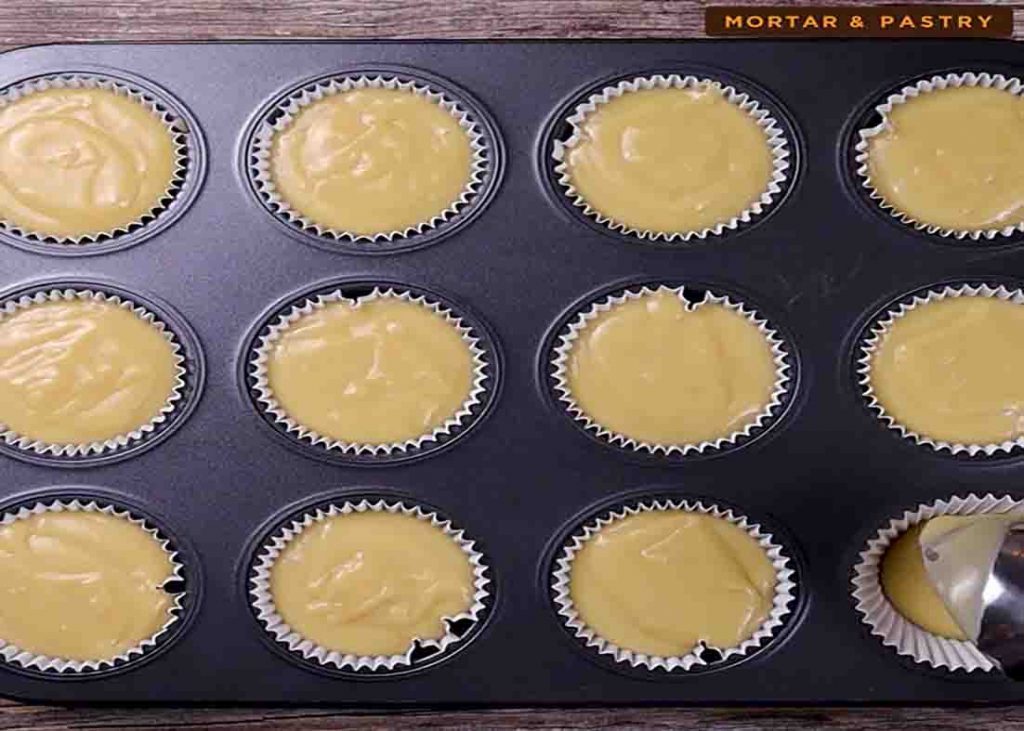 Putting the muffin mixture to the muffin tins