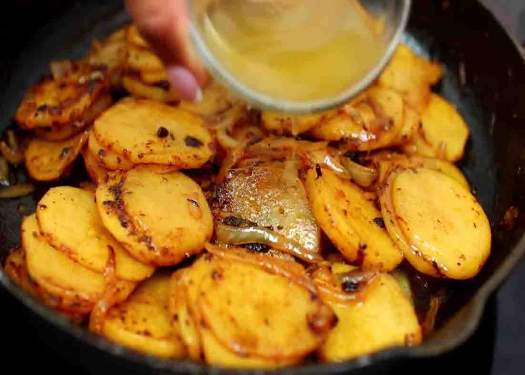 Adding the chicken broth to the pan-fried potatoes