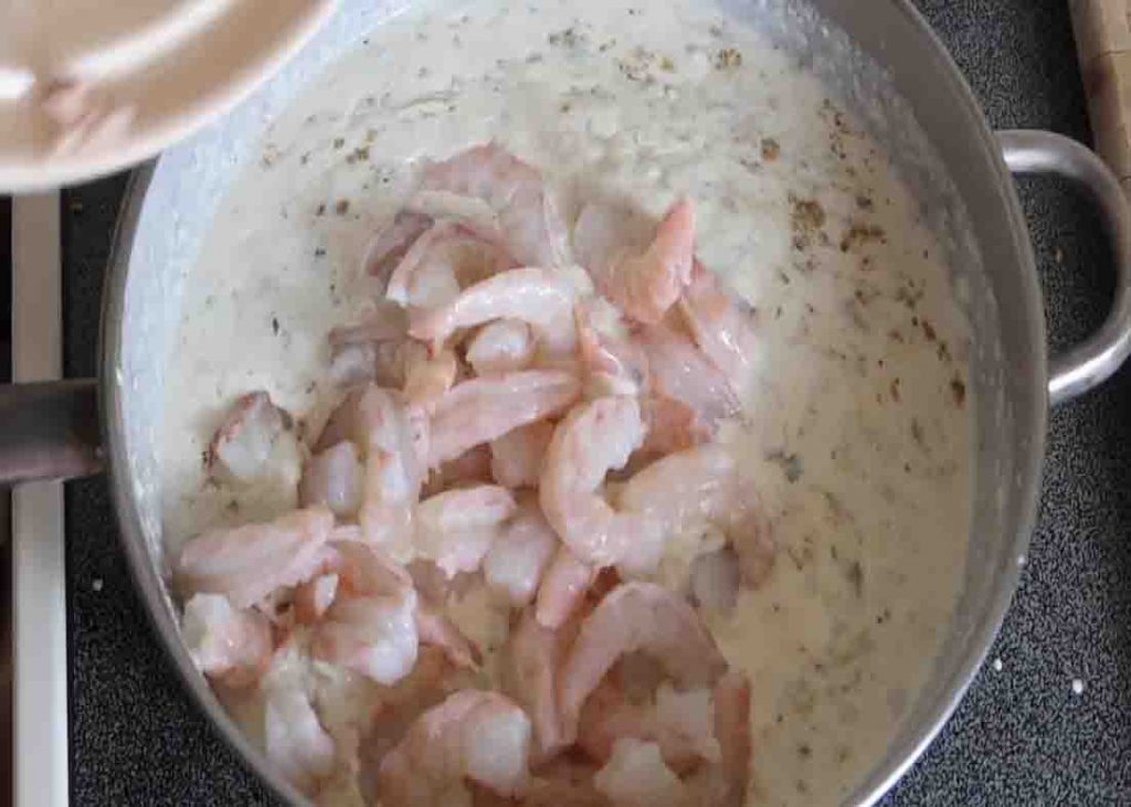 Adding the shrimp and crab meat on the pan 