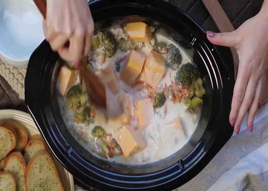 Mixing in the cheese into the slow cooker broccoli cheese soup