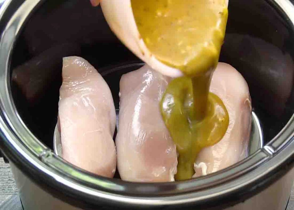 Pouring the honey mustard sauce mixture over the chicken breasts