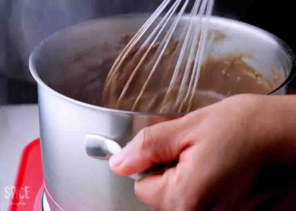 Stirring while cooking the chocolate pudding until thickened