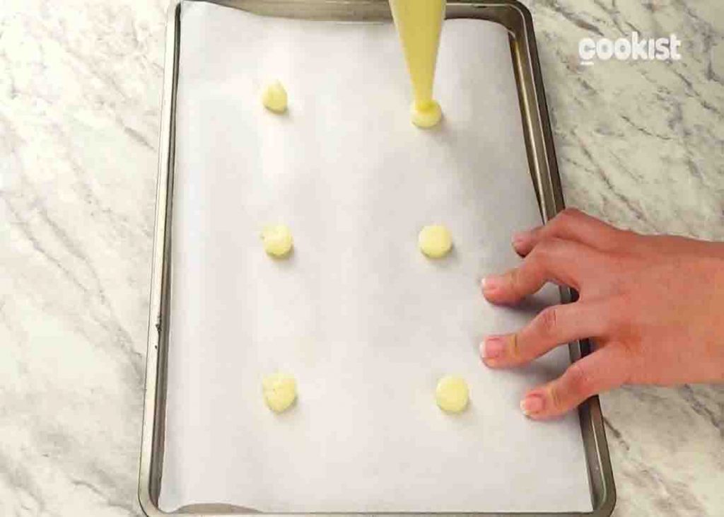 Piping out the mashed potato on the tray to make the potato chips