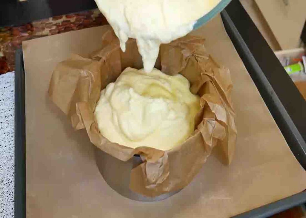 Pouring the batter to the cake mold lined with baking paper