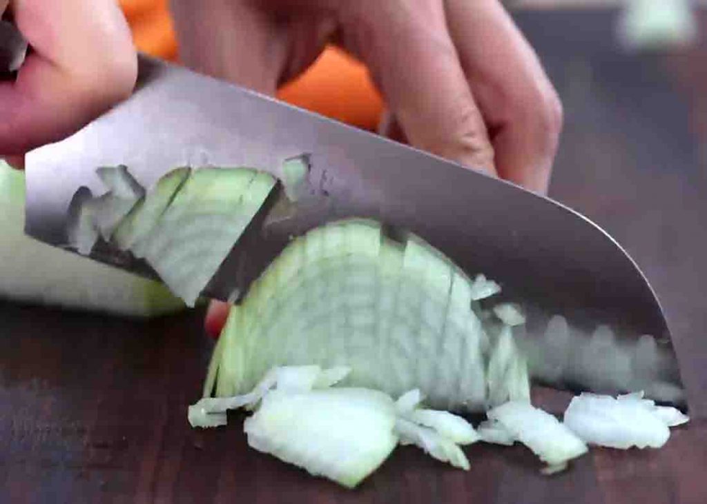 Chopping onion for the creamy chicken and rice recipe