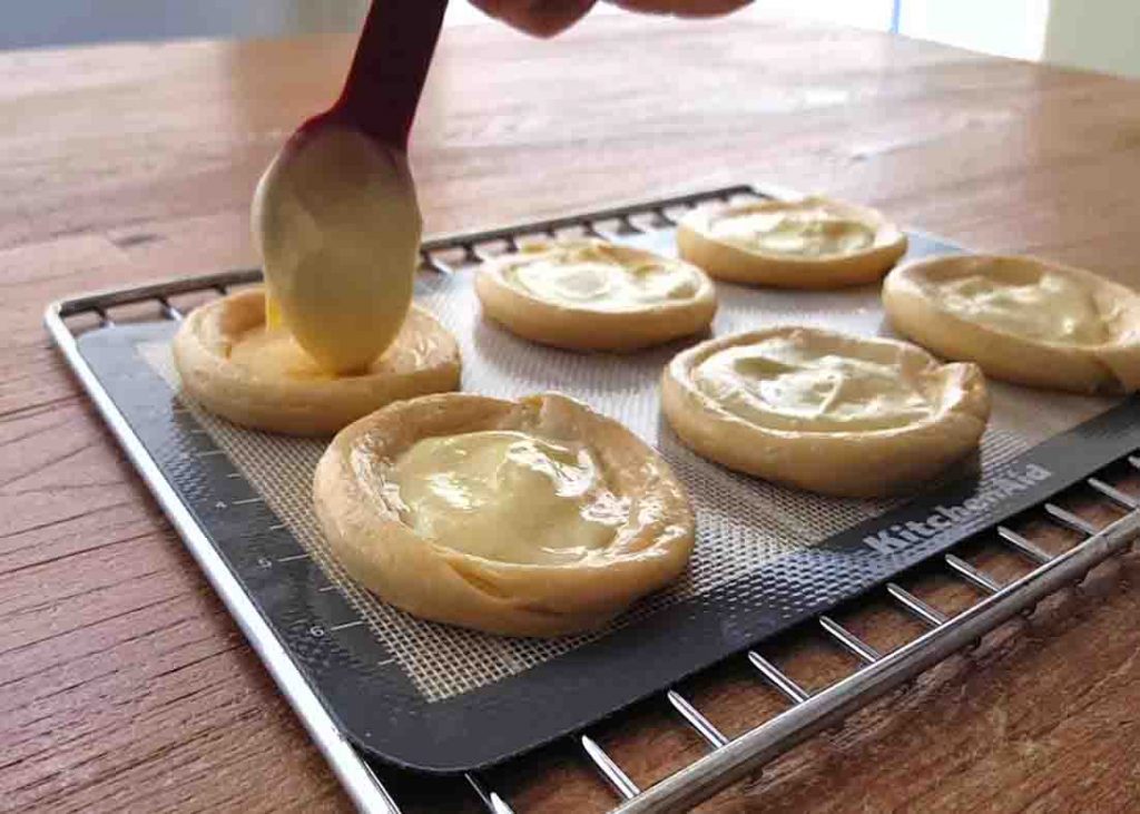 Adding the cream cheese mixture to the crescent roll dough