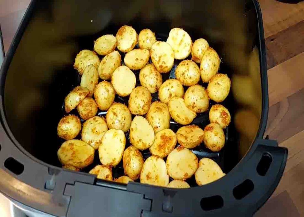 Placing the baby potatoes in the air fryer basket