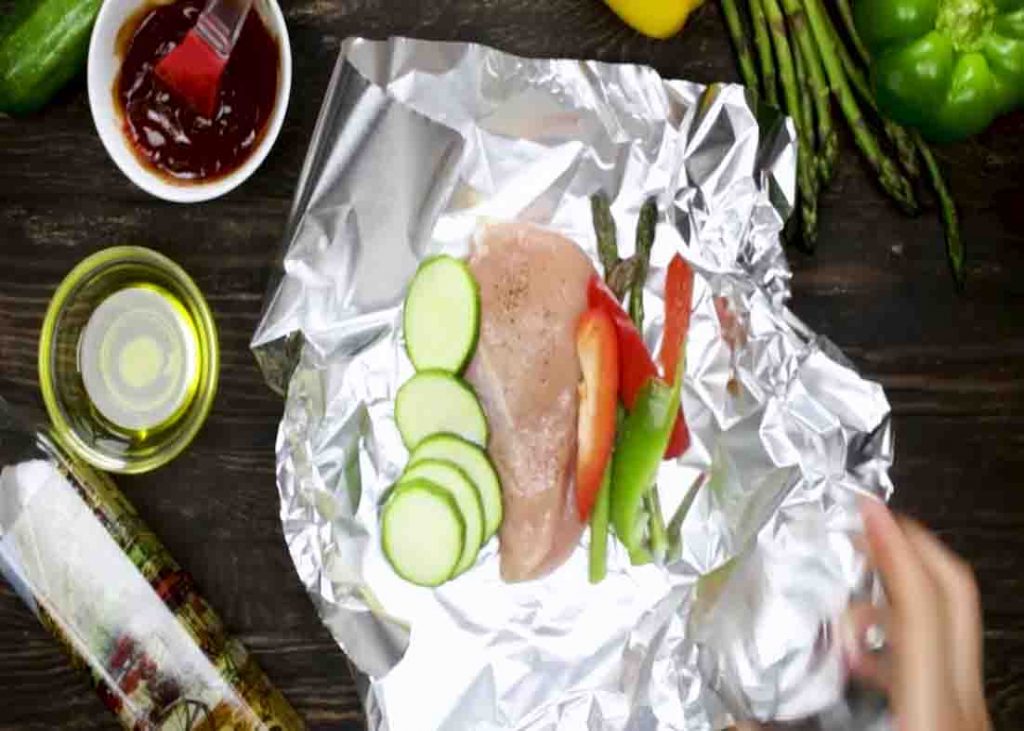 Adding the chicken and veggies in the foil