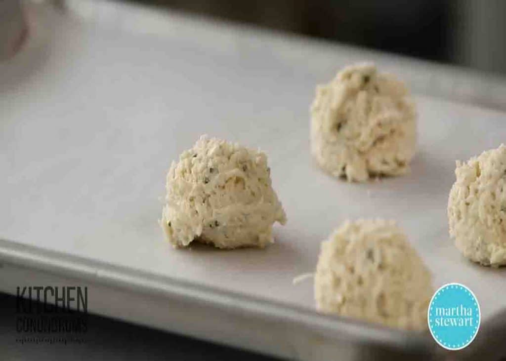 Scooping the cheddar biscuit mixture into the baking sheet