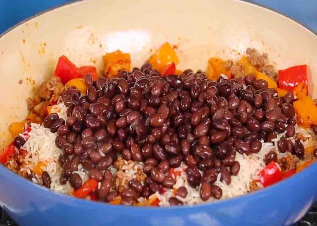 Adding the rice and black beans to the beef taco skillet