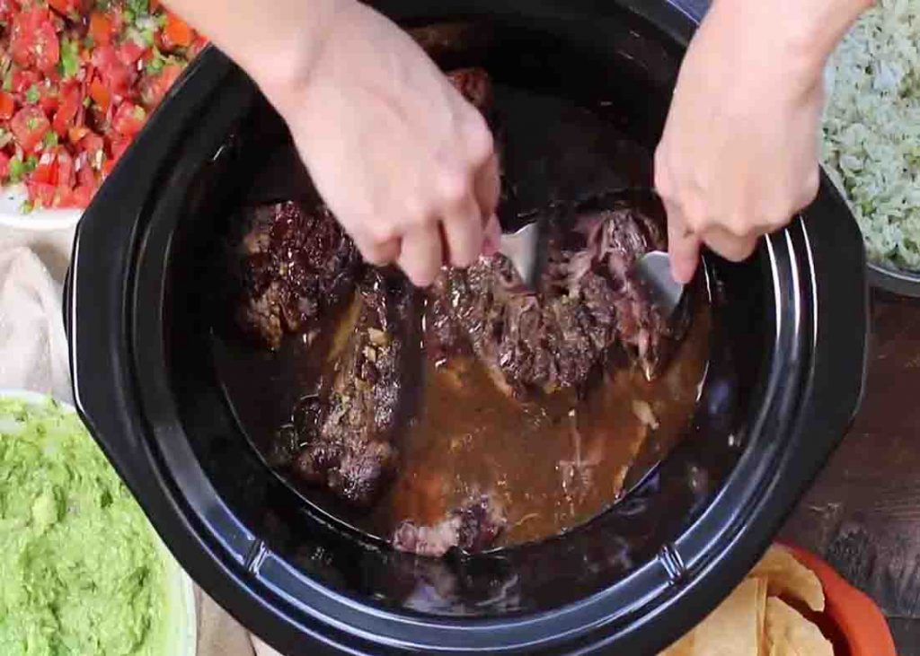 Shred the chipotle barbacoa after slow cooking