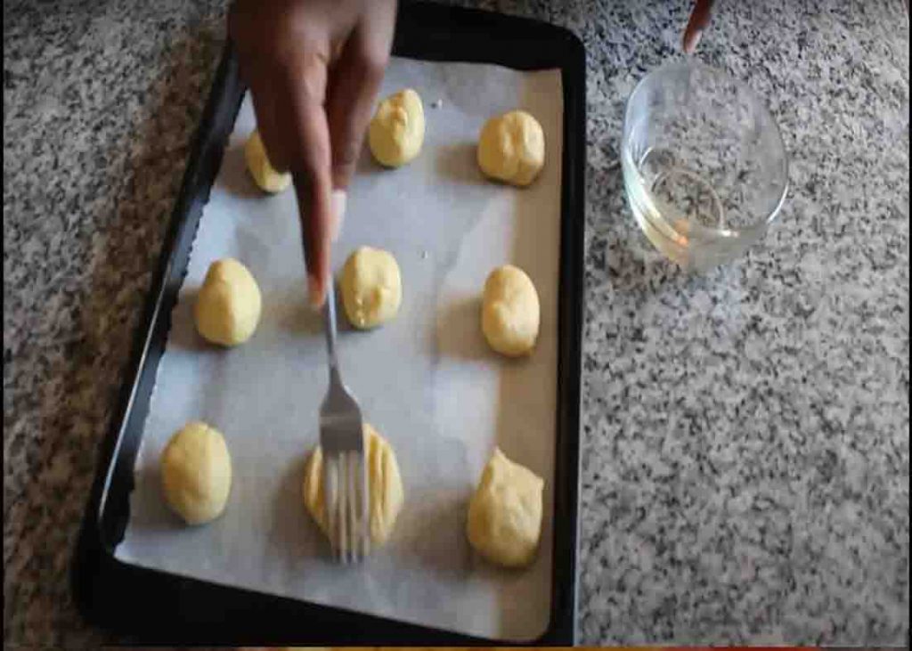 Flattening the biscuits with oiled fork