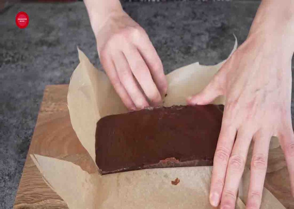 Removing the chocolate bar from the mold and slicing it to bite-size pieces