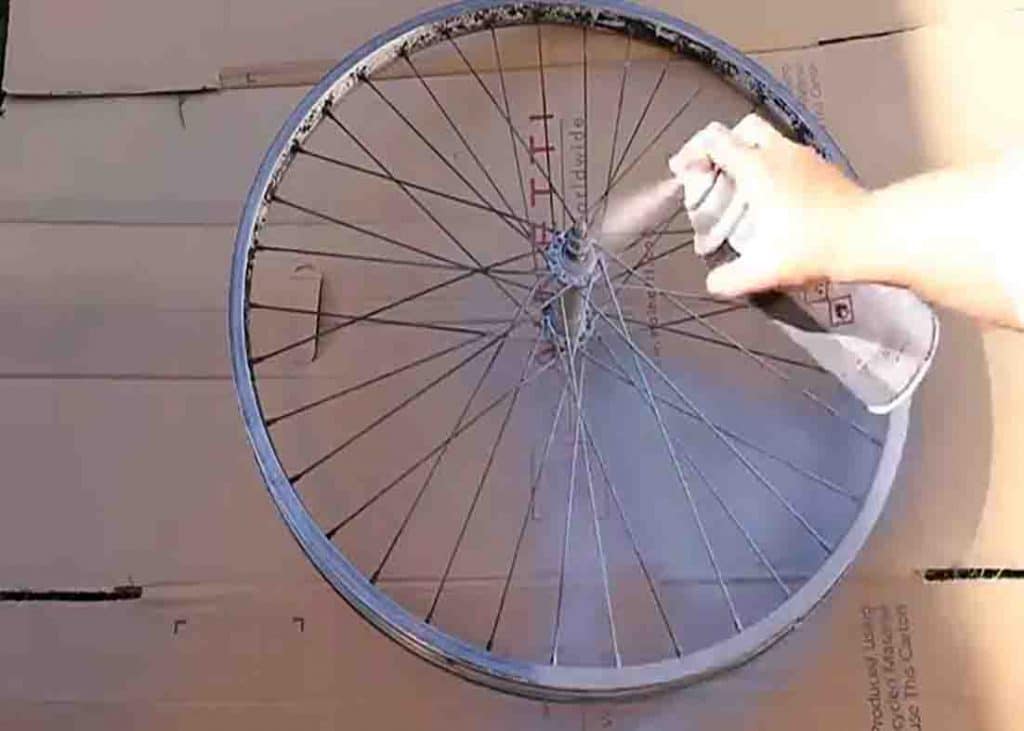 Spraying some primer to the bike wheel