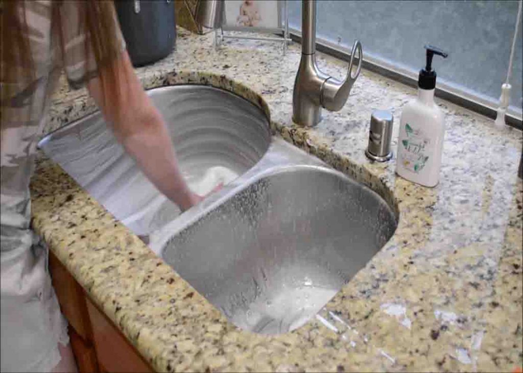 Scrubbing clean your sink to make it smell fresh