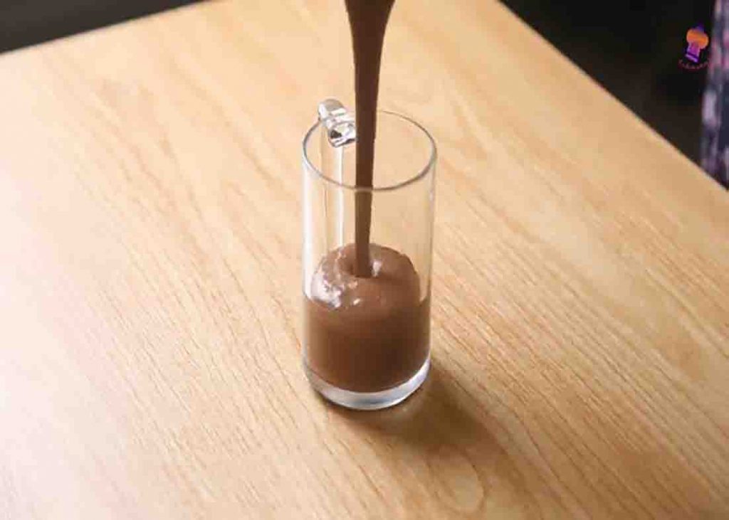 Transferring the oats chocolate smoothie to the glass