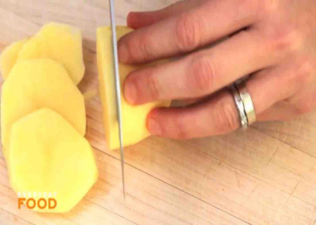 Slicing the potatoes thinly for the casserole recipe