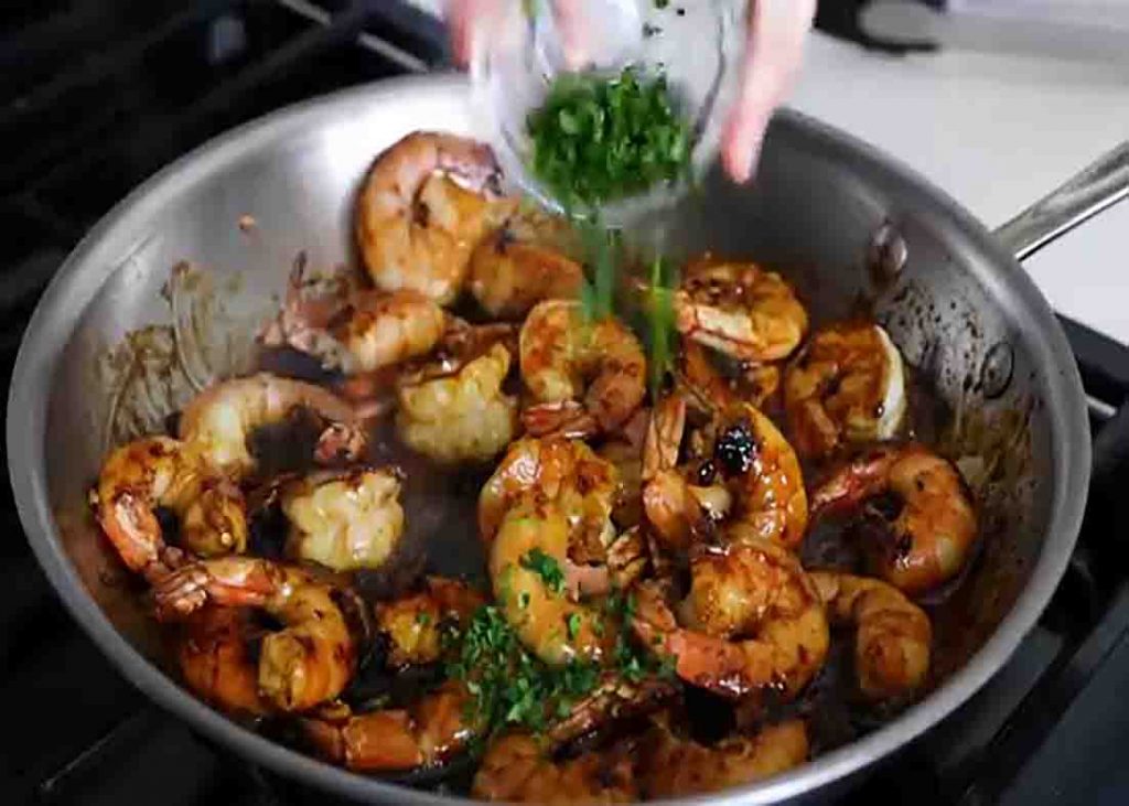 Garnishing the honey garlic shrimp with cilantro