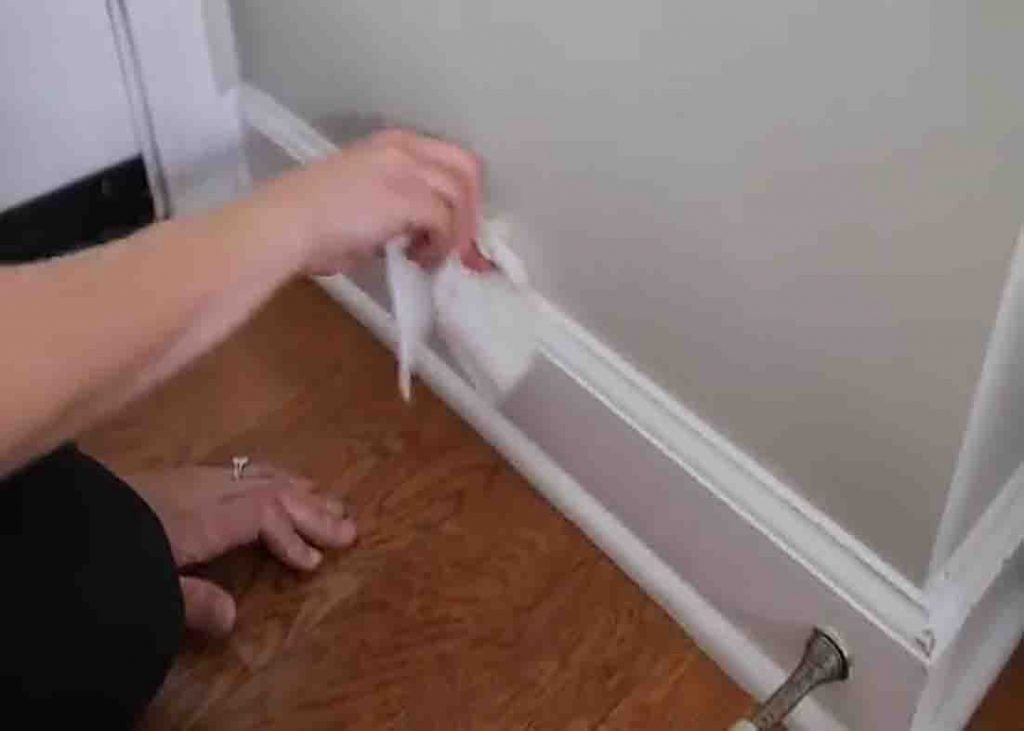 Cleaning baseboards with baby wipes