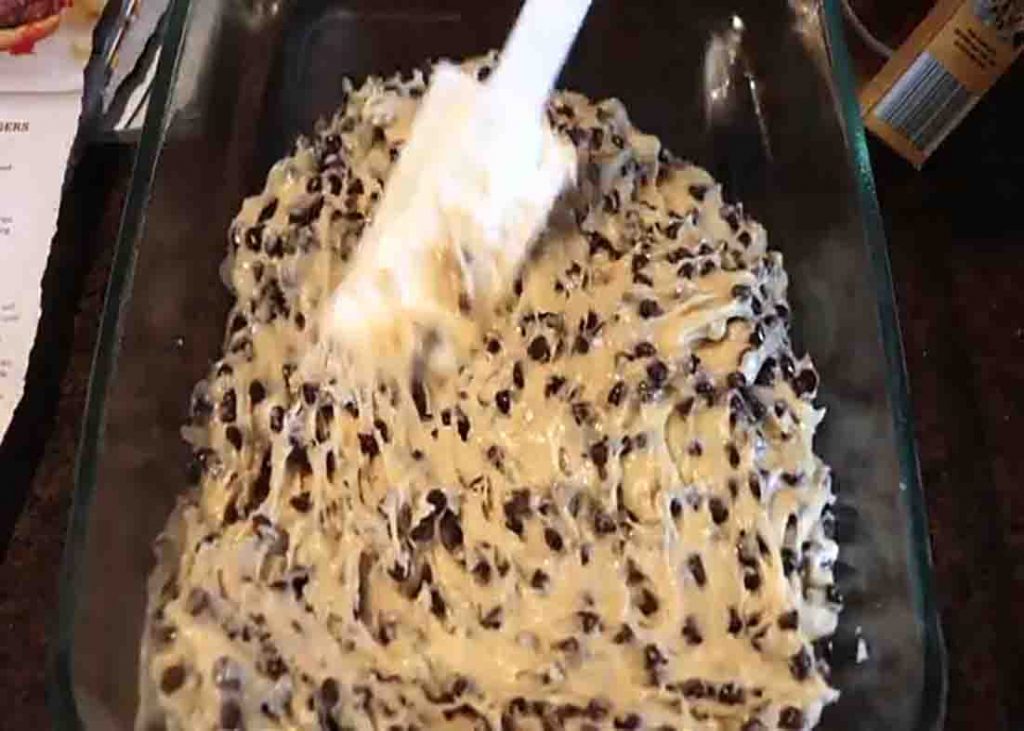 Spreading the cookie batter to the casserole dish