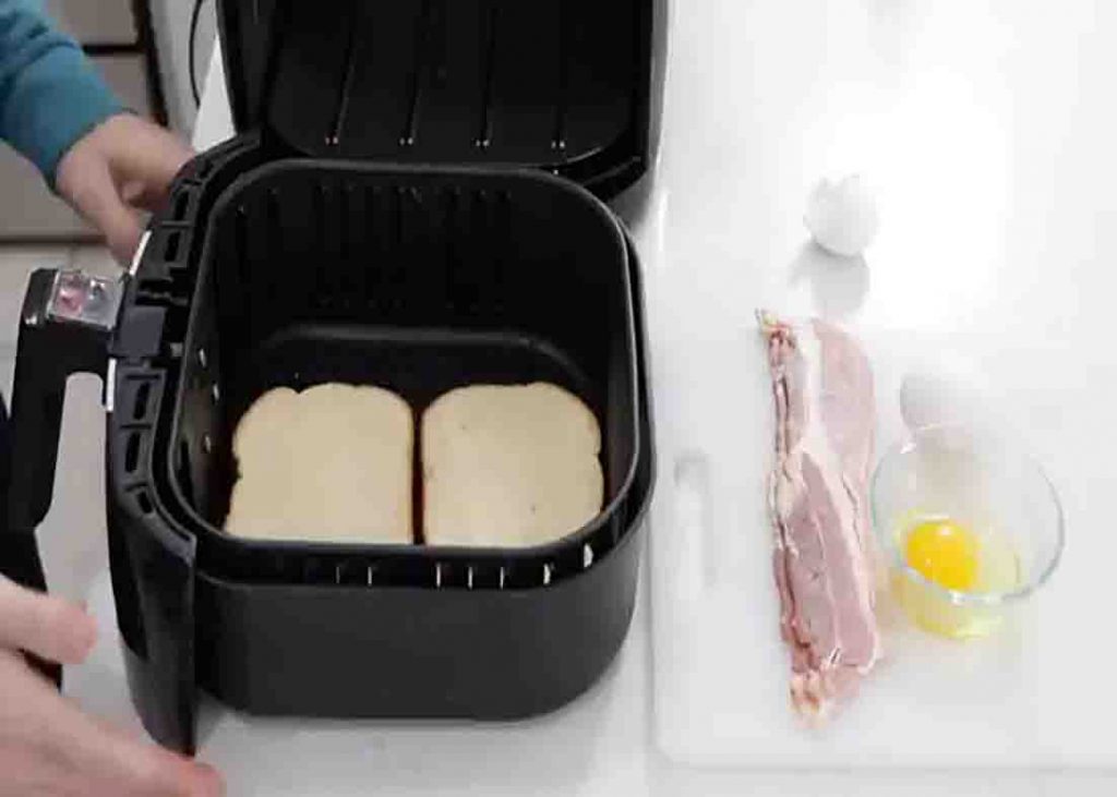 Placing the slices of bread in the air fryer basket