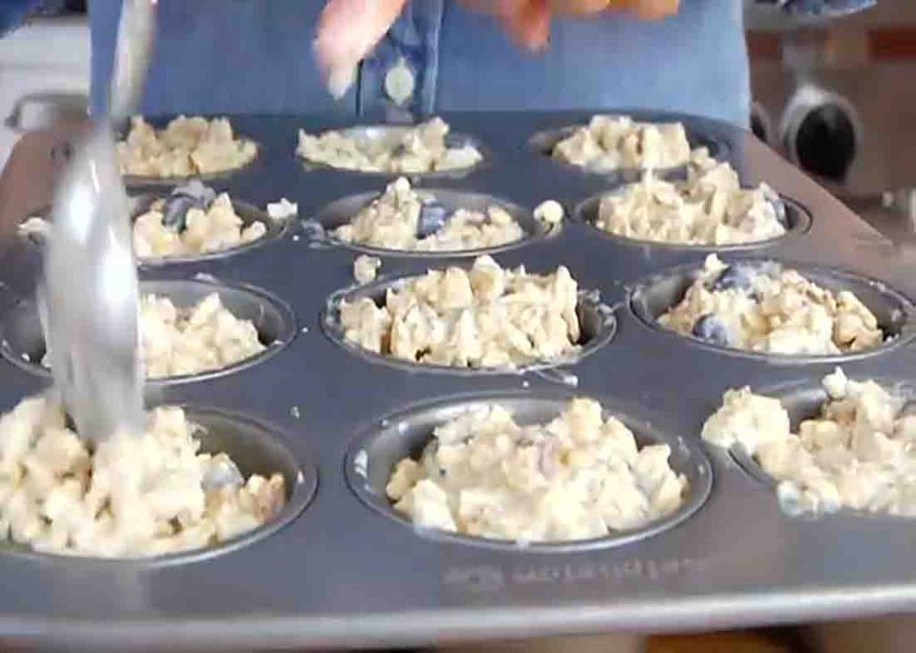 Dividing the blueberry lemon muffin batter to the muffin pan