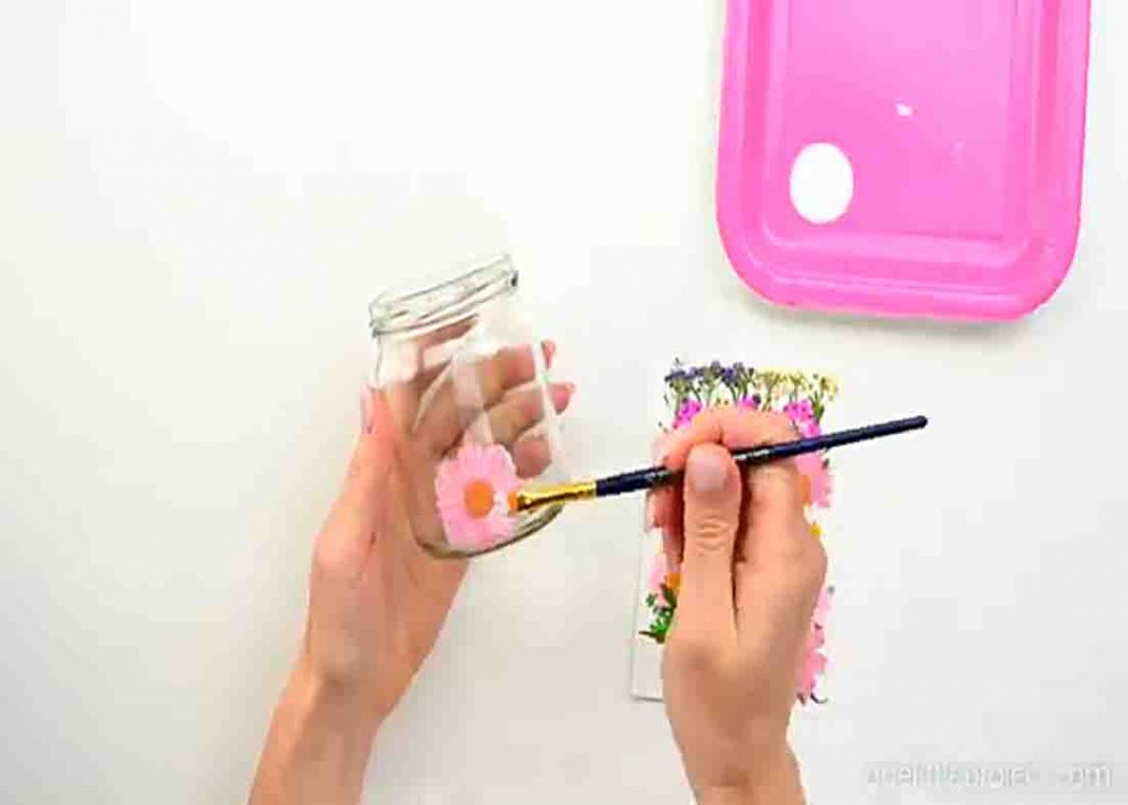 Gluing the dried flowers on the mason jar