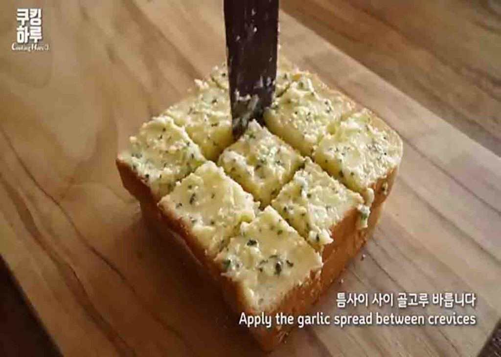 Spreading the garlic spread over the bread