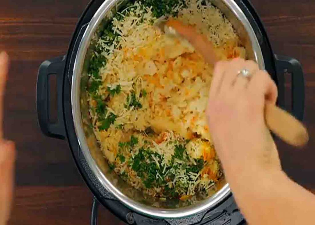 Mixing the chicken and rice with cheese and parsley
