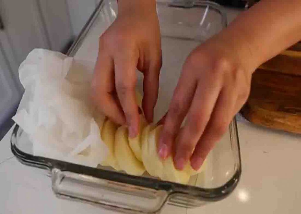 Layering the potato slices in the baking dish