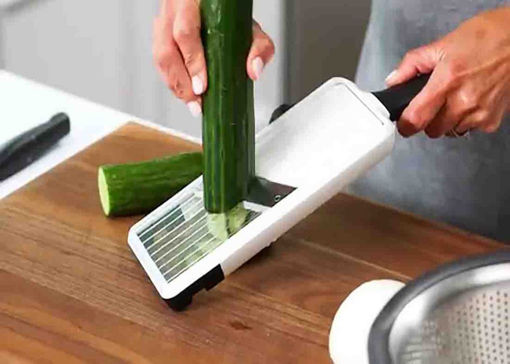 Slicing the cucumbers thinly for the salad recipe
