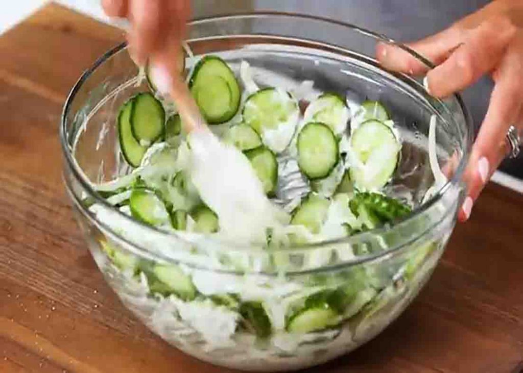 Tossing the cucumbers with the homemade dressing