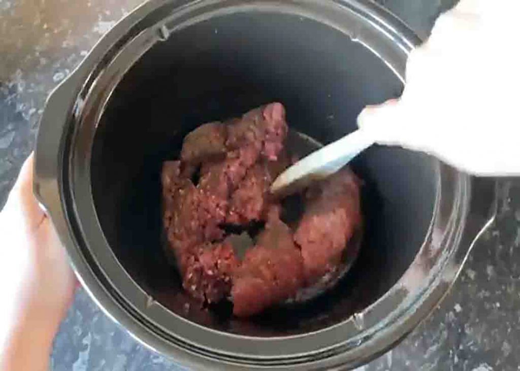 Adding the ground beef to the slow cooker