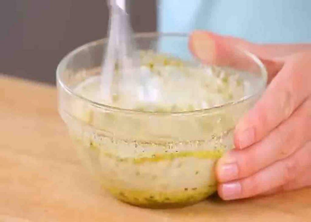 Mixing the ingredients for the pesto potato salad dressing