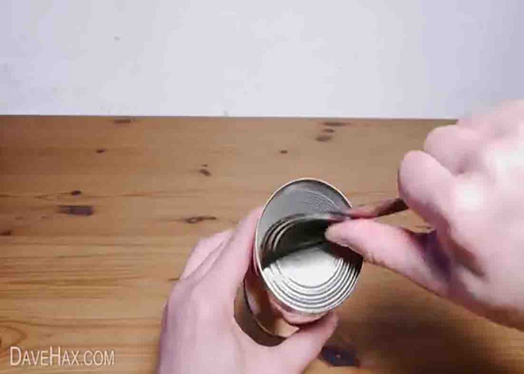 Opening the tin can to turn it into a bird feeder