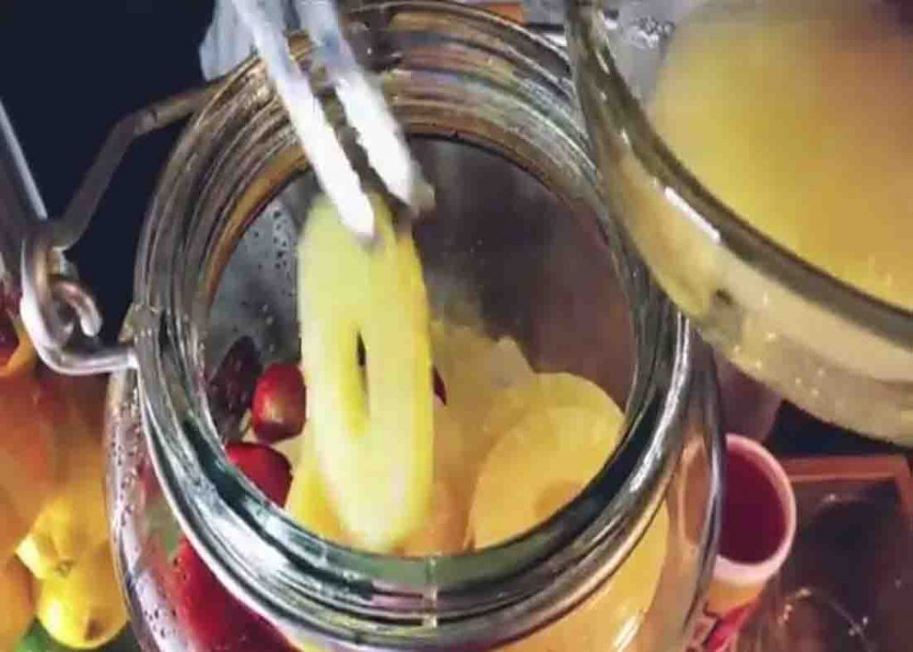 Adding the pineapple slices to the pineapple hunch punch