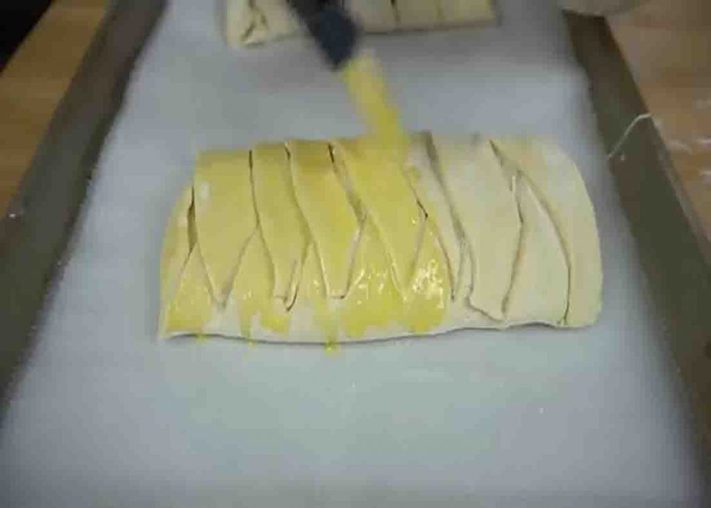 Brushing the cream cheese danish with eggwash