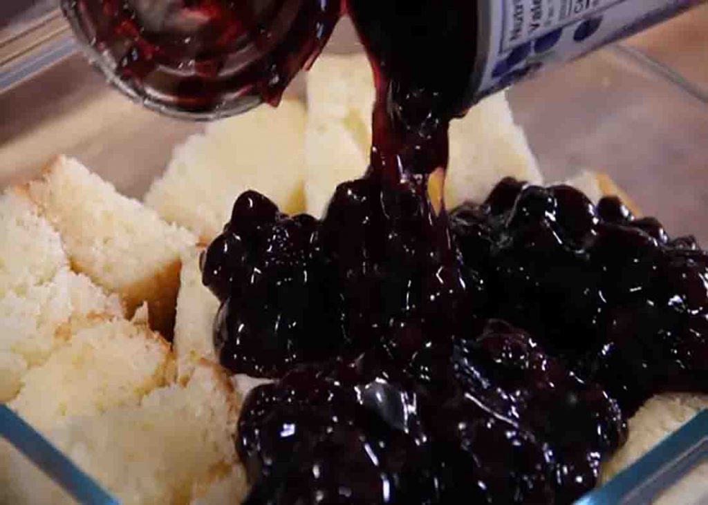 Adding the blueberry filling over the pound cake