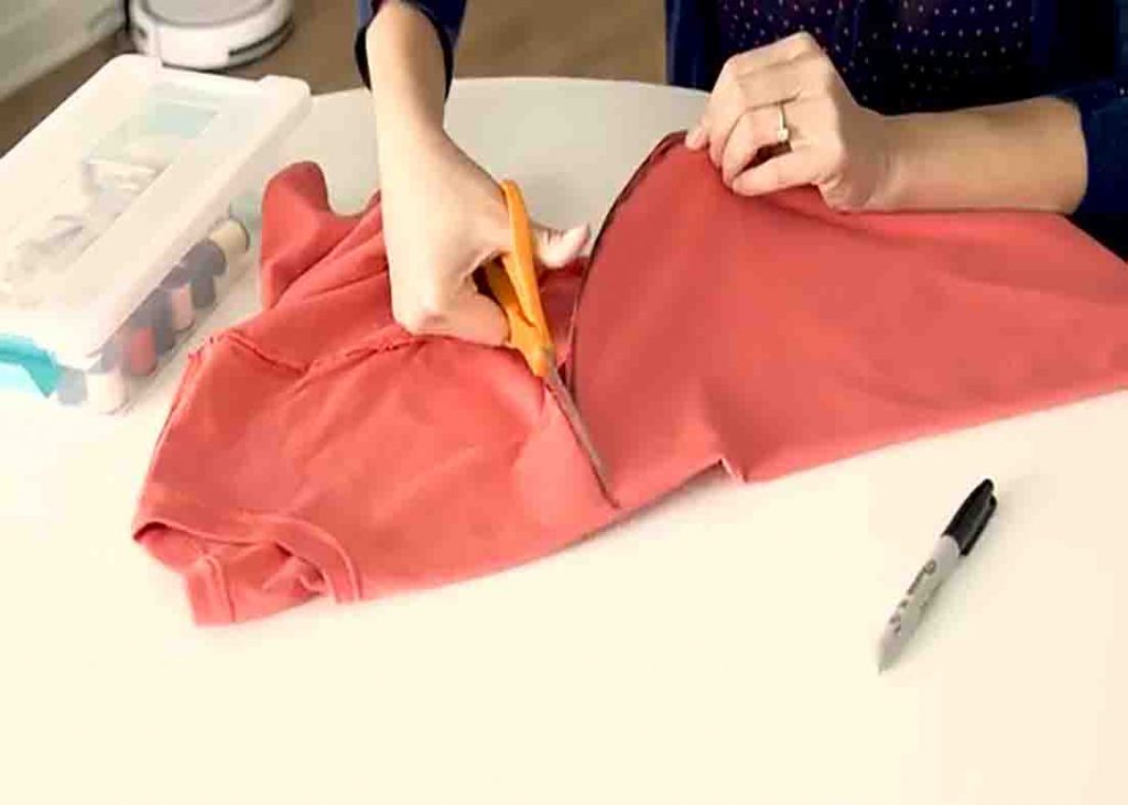 Cutting the t-shirt to make the grocery bag