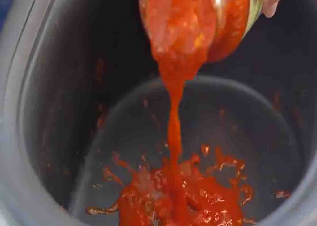 Adding the pasta sauce on the crockpot