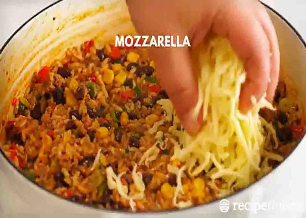 Topping the Mexican ground beef rice with more cheese