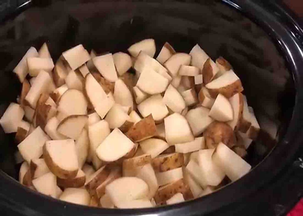Adding the potatoes in the slow cooker