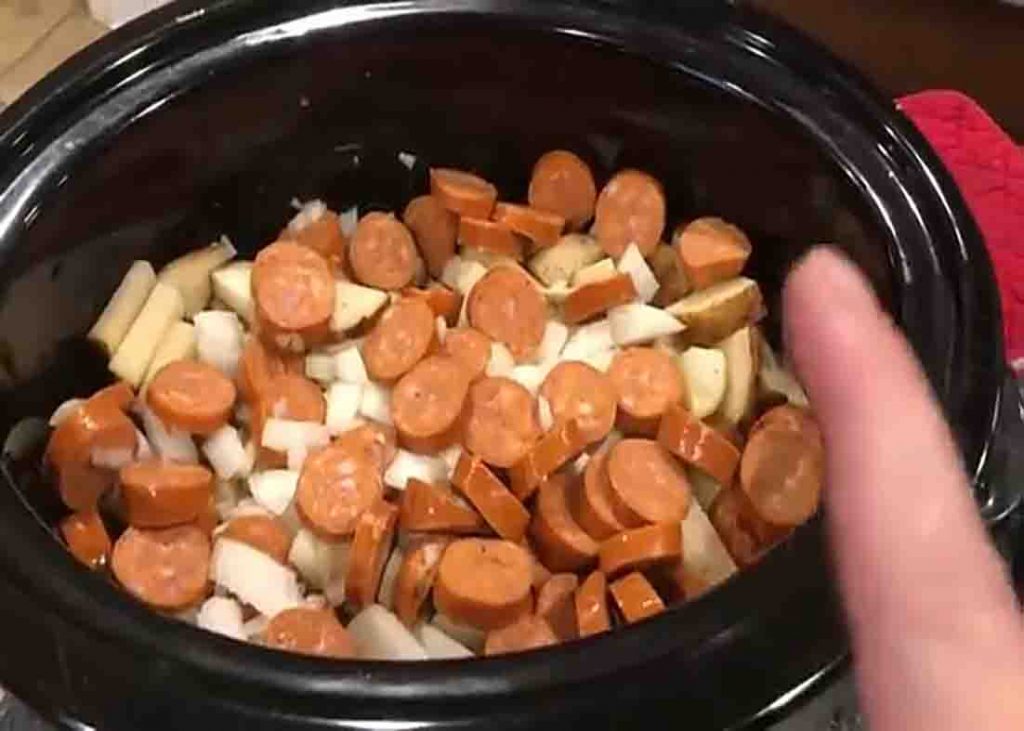Adding the sausages to the slow cooker