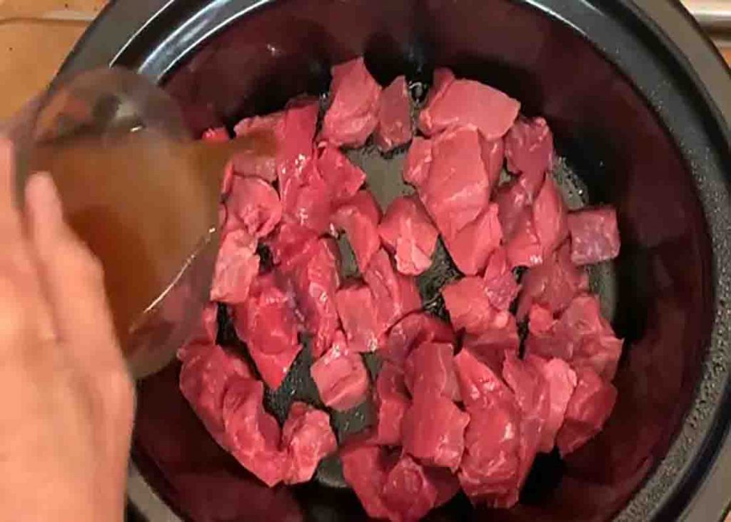 Adding the stew meat to the crockpot