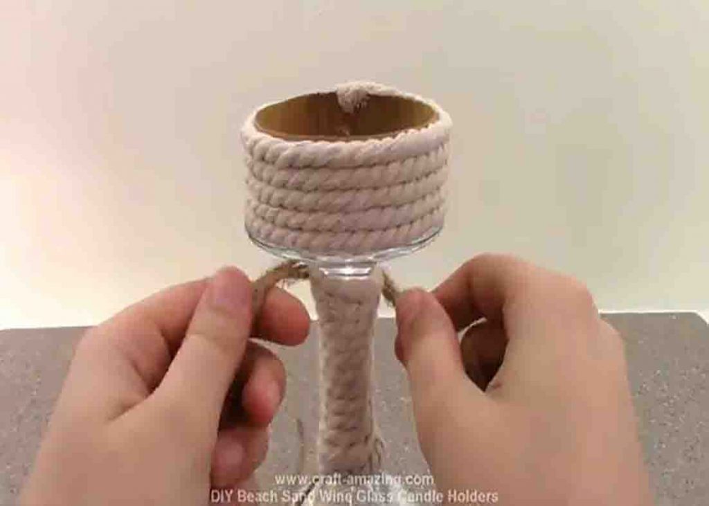 Tying a bow to the beach sand candle holder