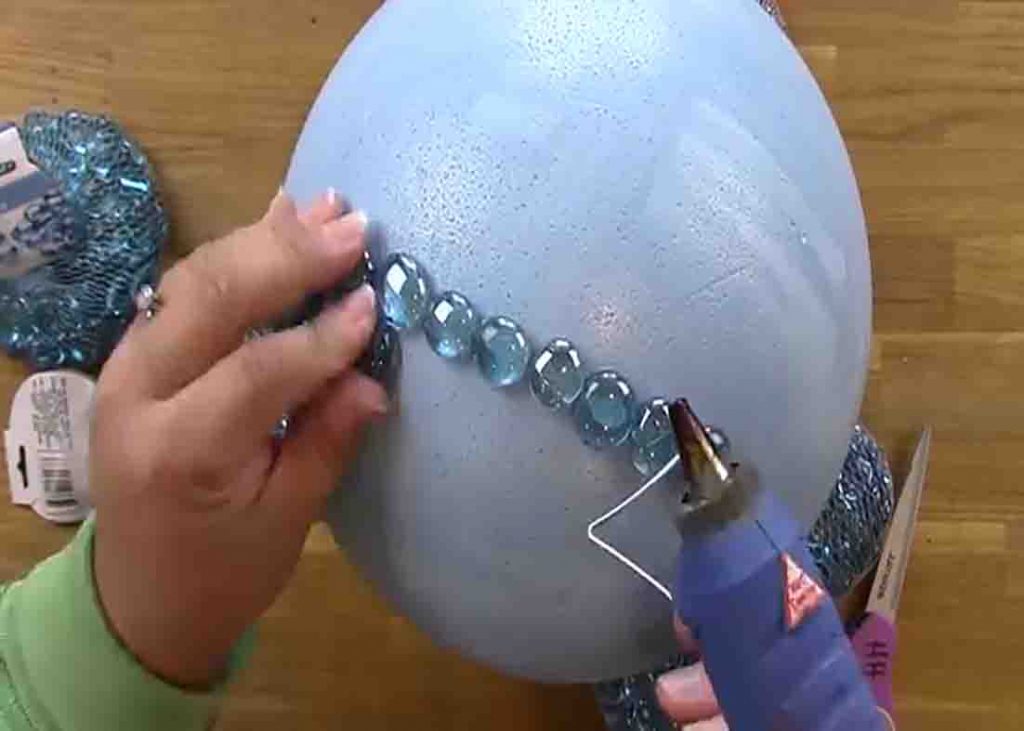 Attaching the glass marbles into the foam ball