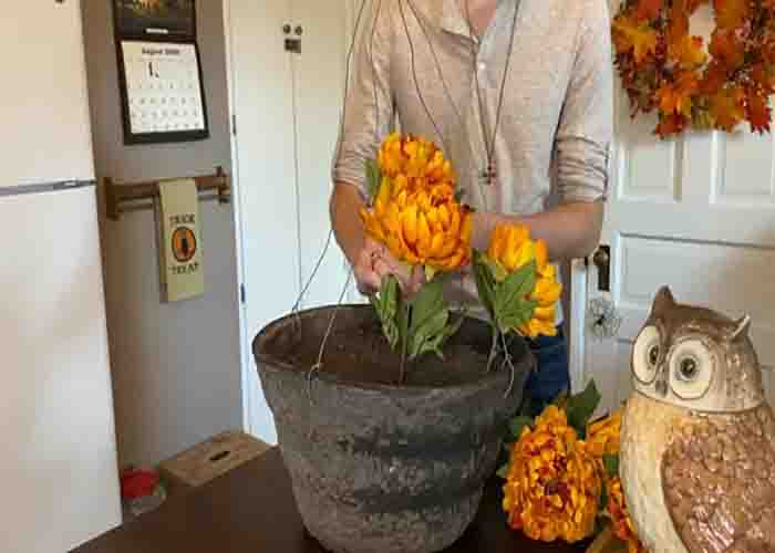 Adding the fall flowers to the hanging basket