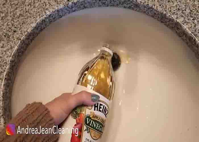 Pouring vinegar down the drain to unclog it