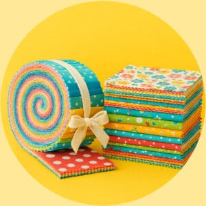 Quilt and sewing projects made with fabric precuts including jelly rolls, charm packs, and layer cakes in colorful prints.