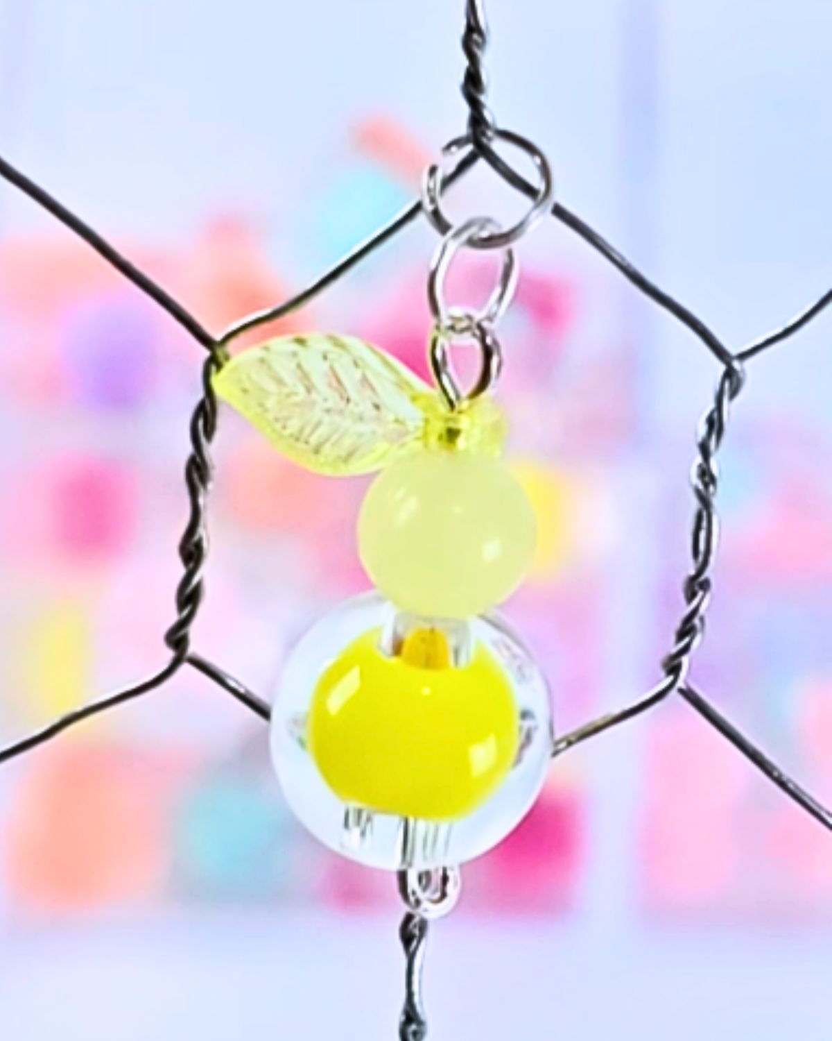 Hanging beaded headpins onto the chicken wire of a picture frame.